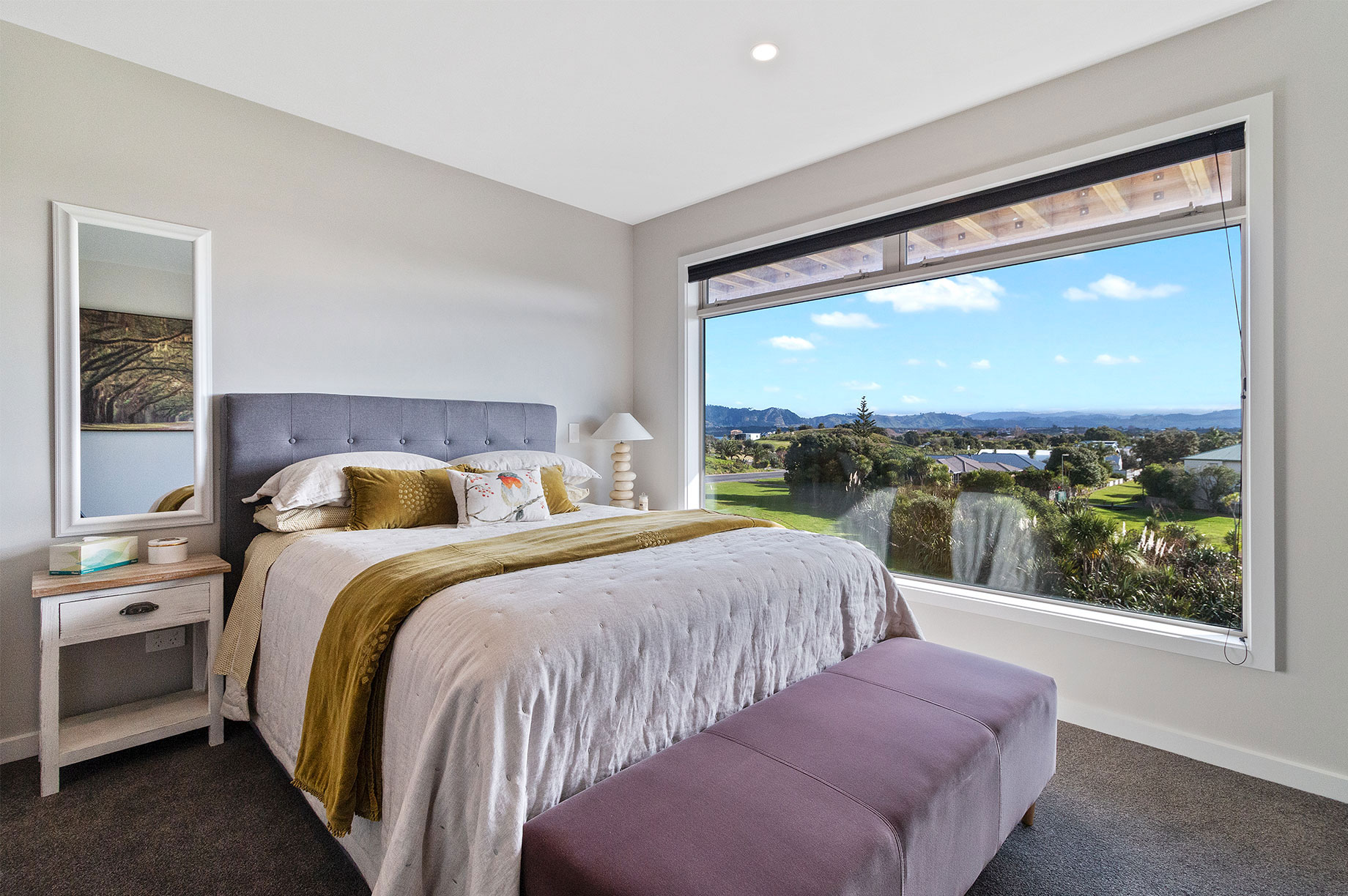 Bedroom with a large window overlooking hills