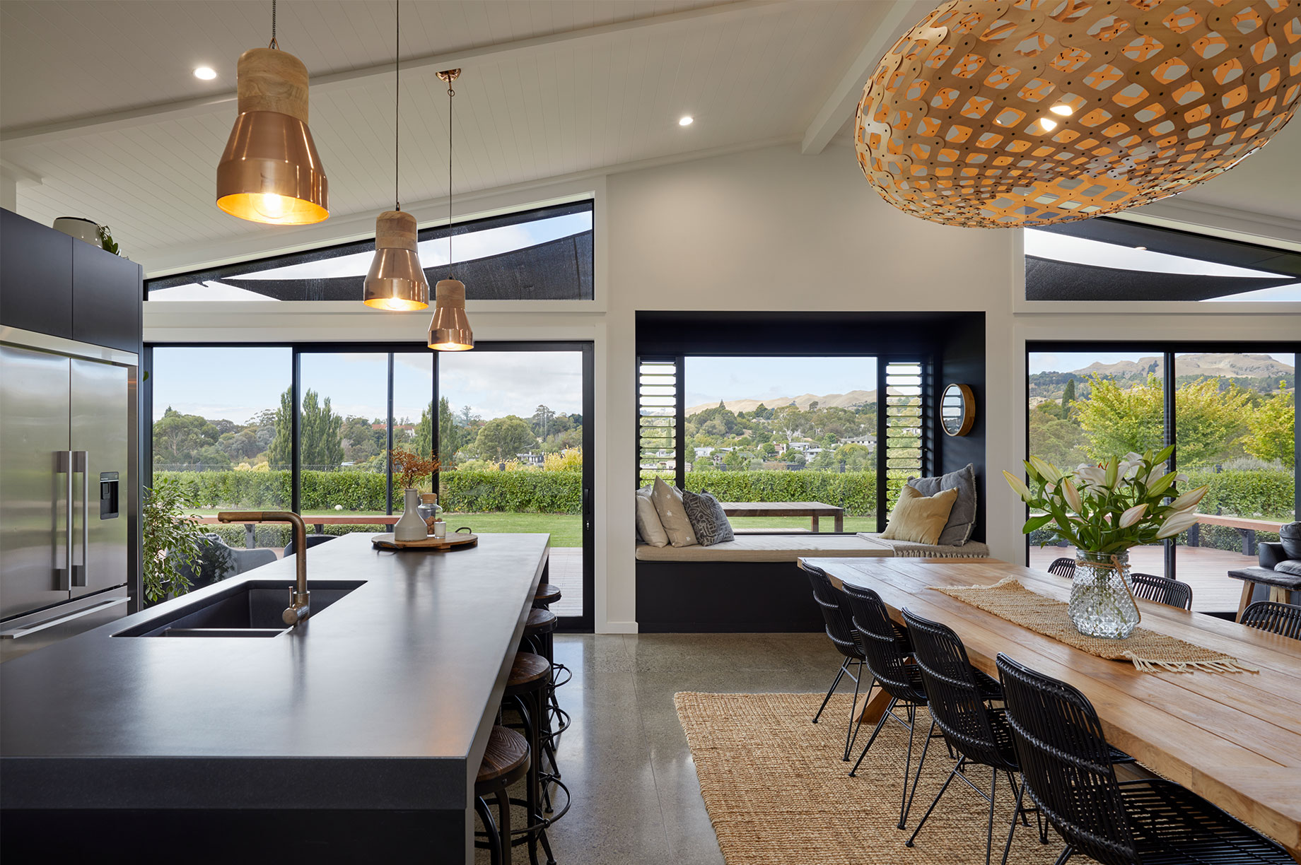 Kitchen and dining area with large windows overlooking trees