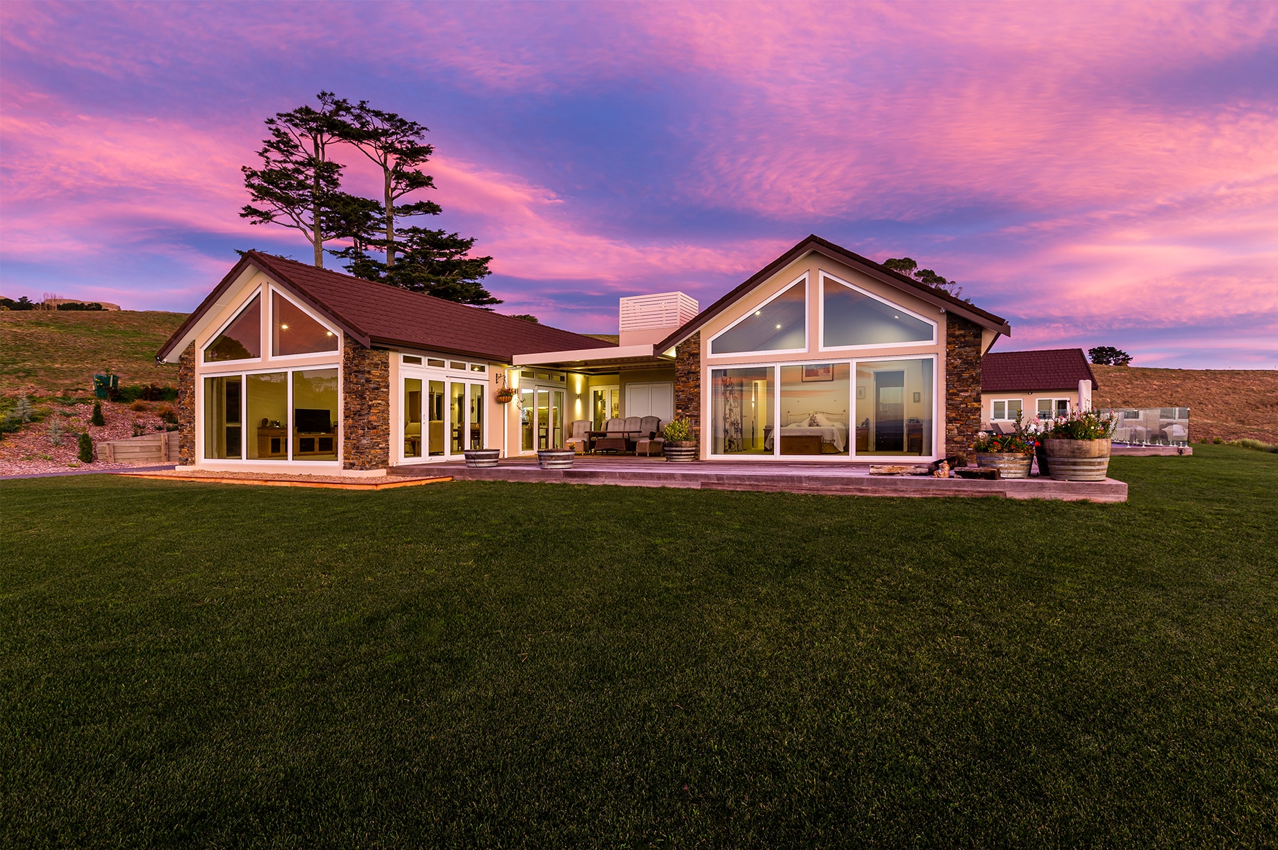 Rural home with floor to ceiling windows during sunset