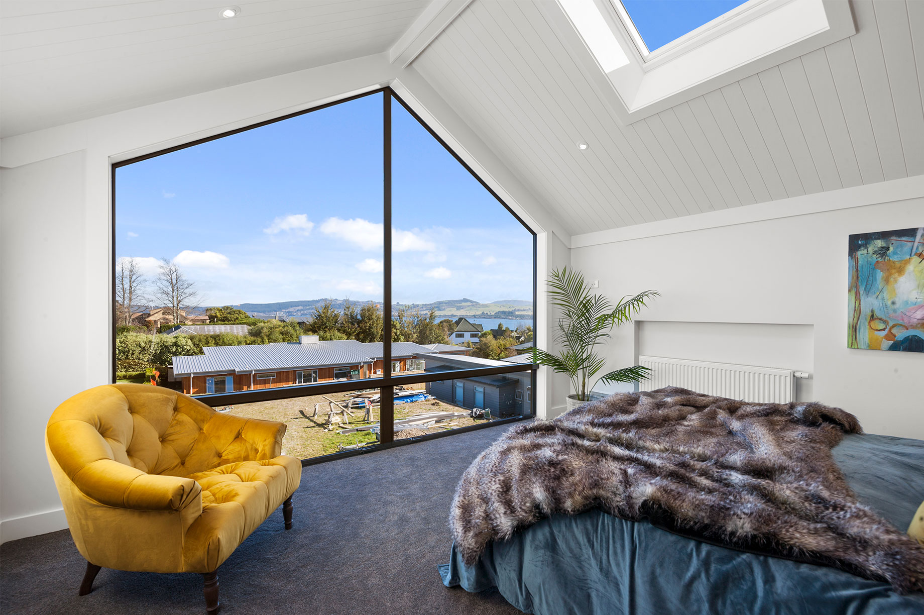 Master bedroom with floor-to-ceiling windows and hill views