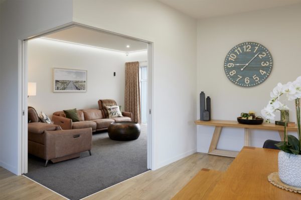 Lounge room with brown couches entrance from dining room
