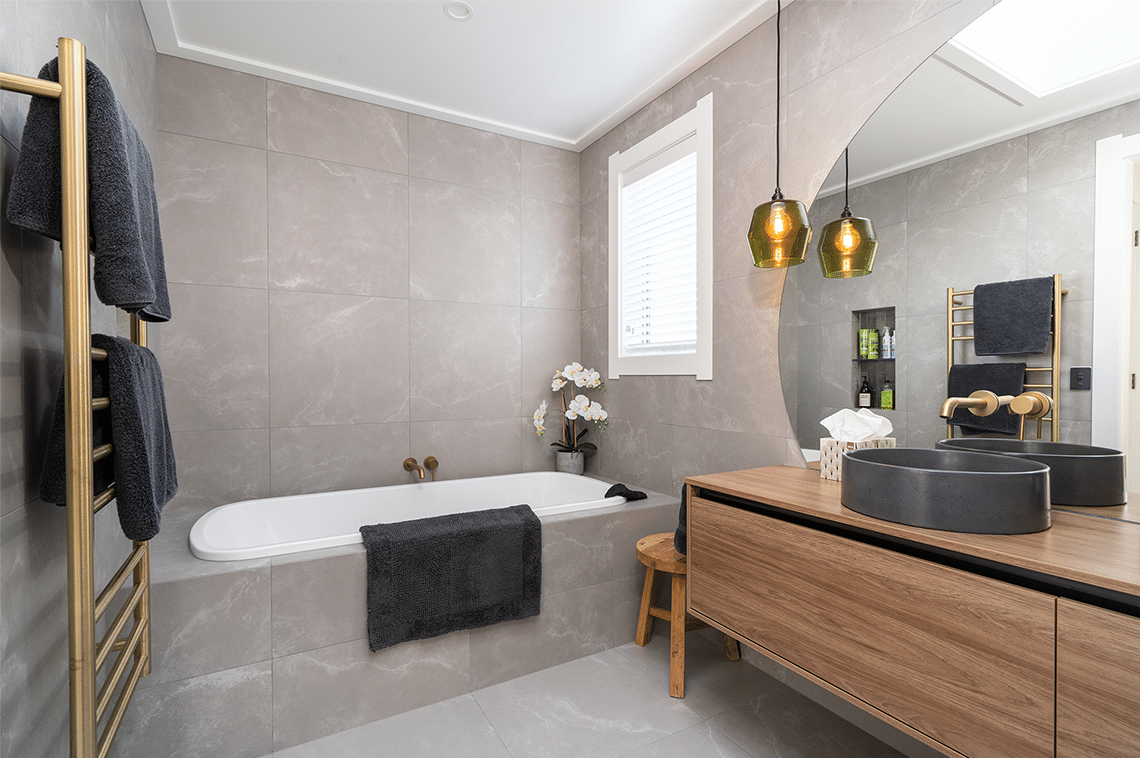 Beige tiled bathroom with wooden cabinets and large mirror