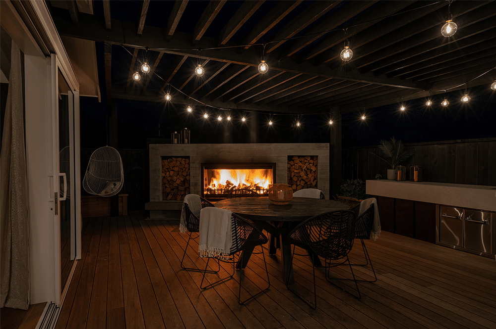 Outdoor living space with a fireplace at night time