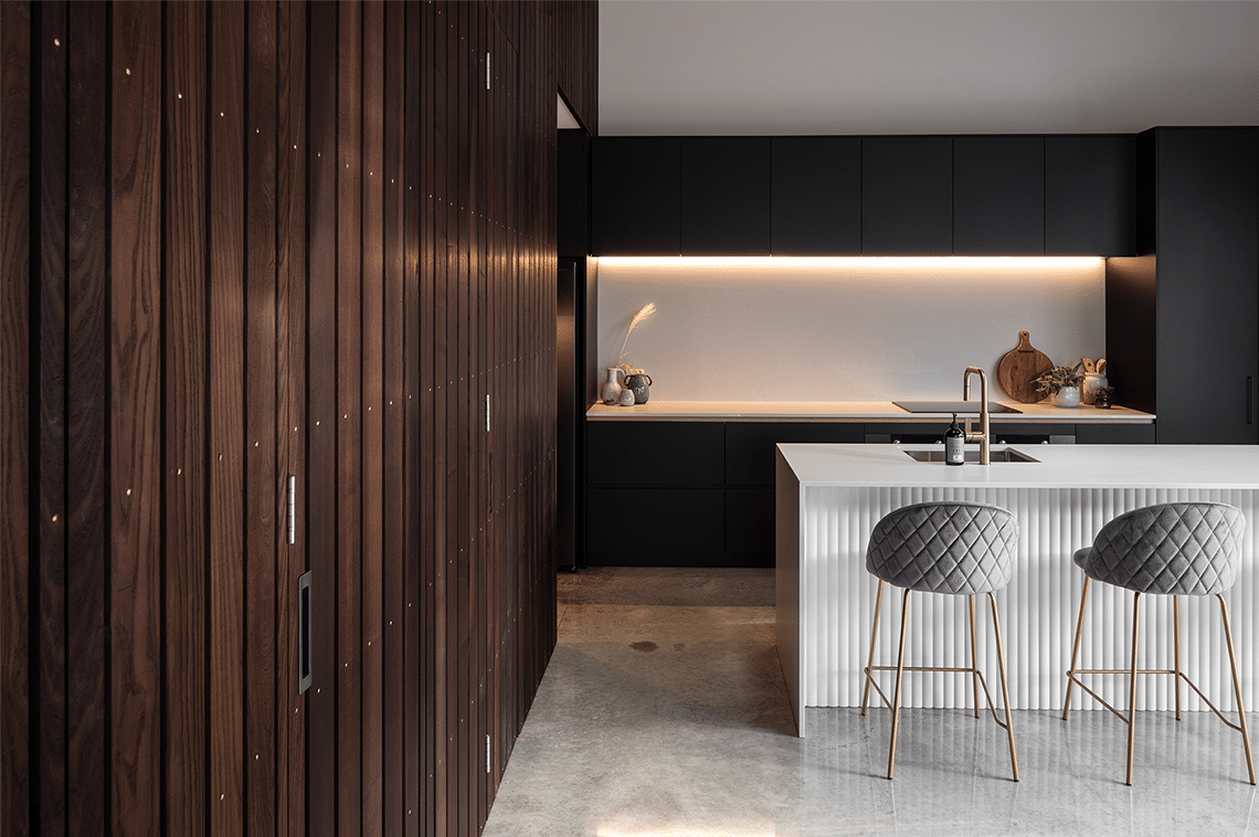 21027-moder-times-dining-kitchen-2 Modern black kitchen with a white kitchen island