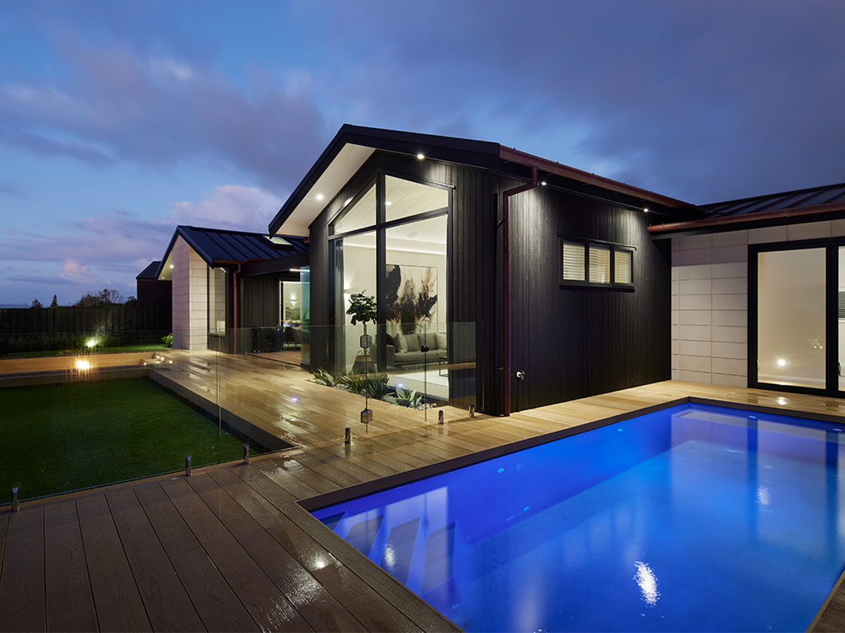 Black house exterior with pool in the evening