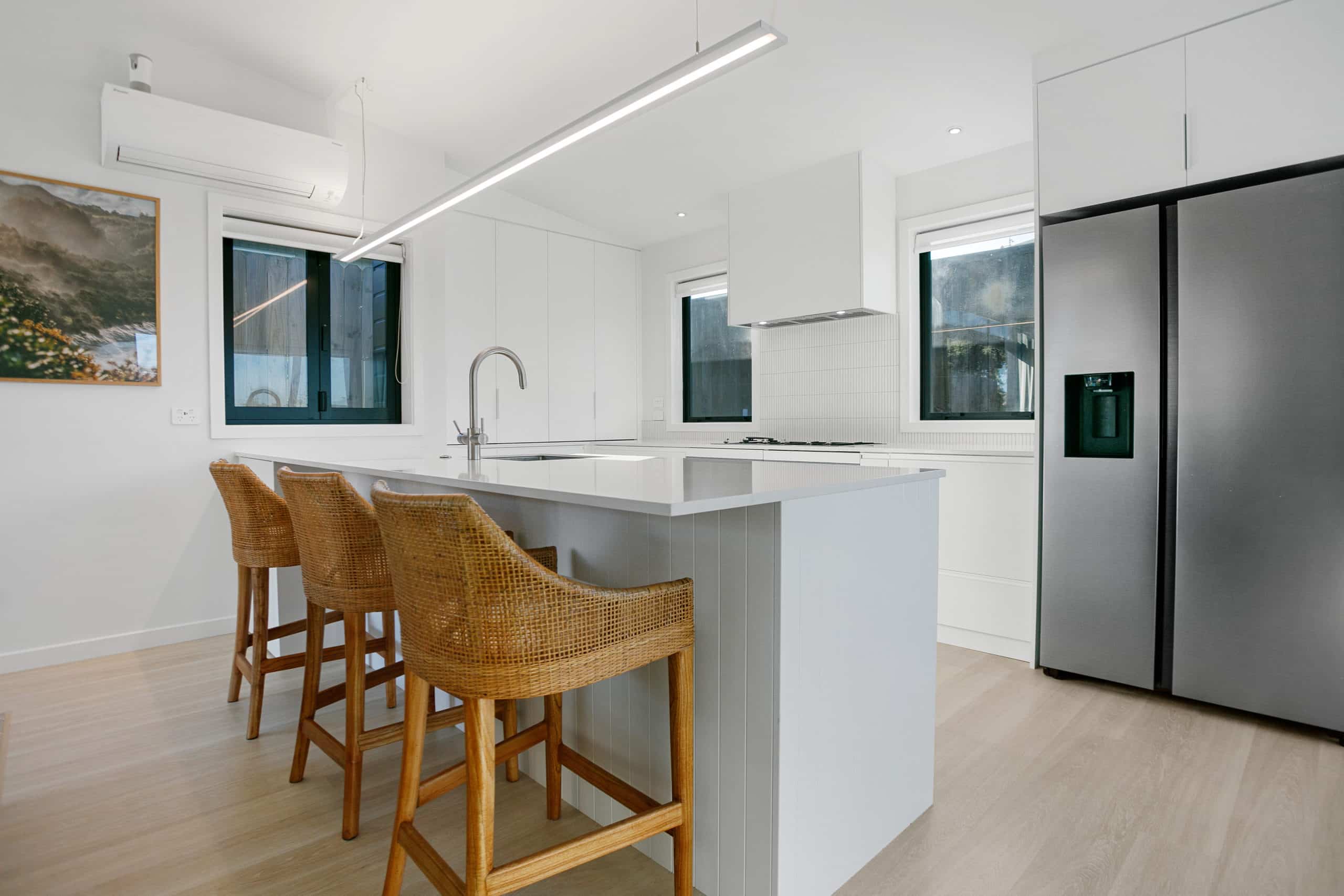 White kitchen interior with wooden bar stools