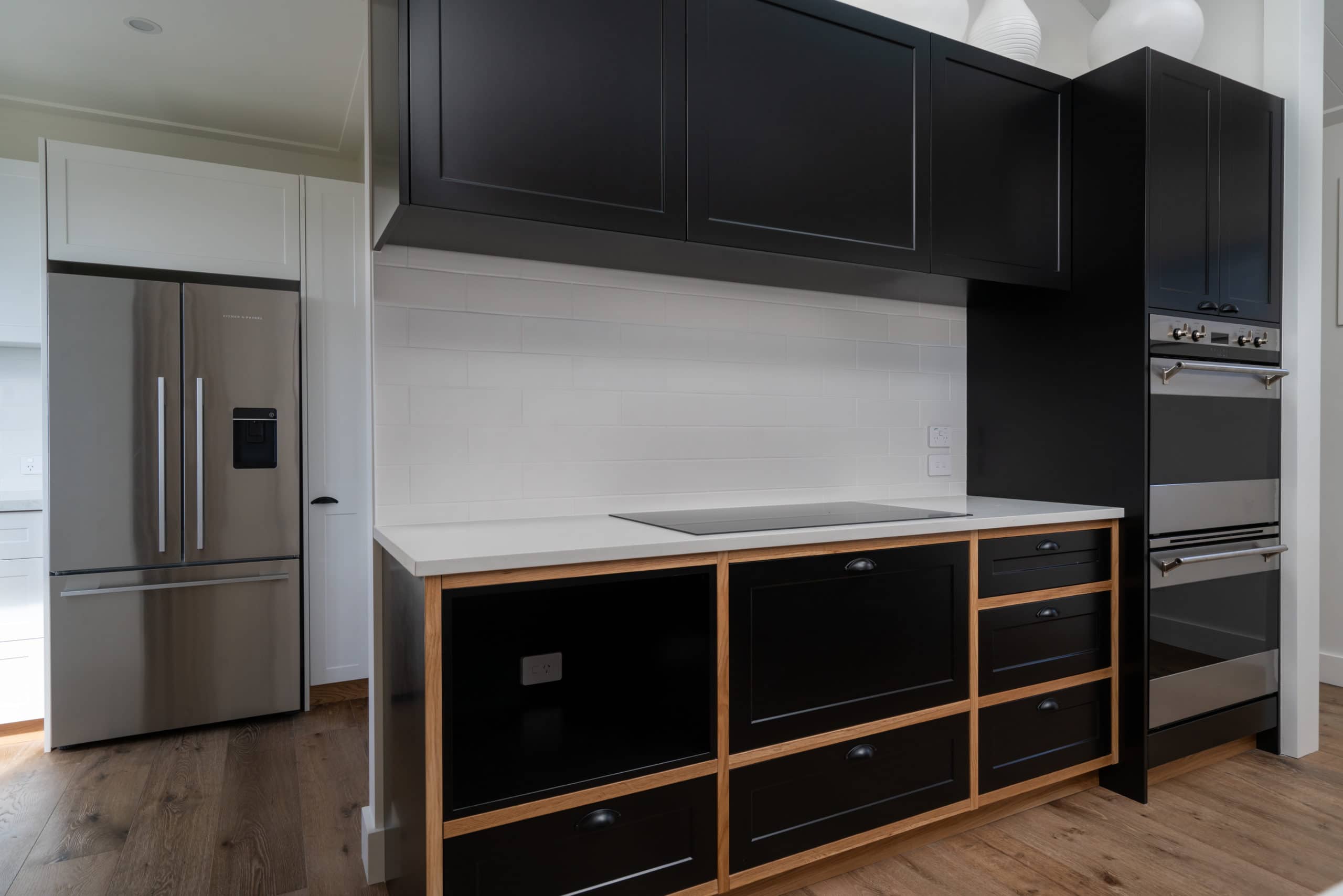 Black kitchen interior with a white bench top
