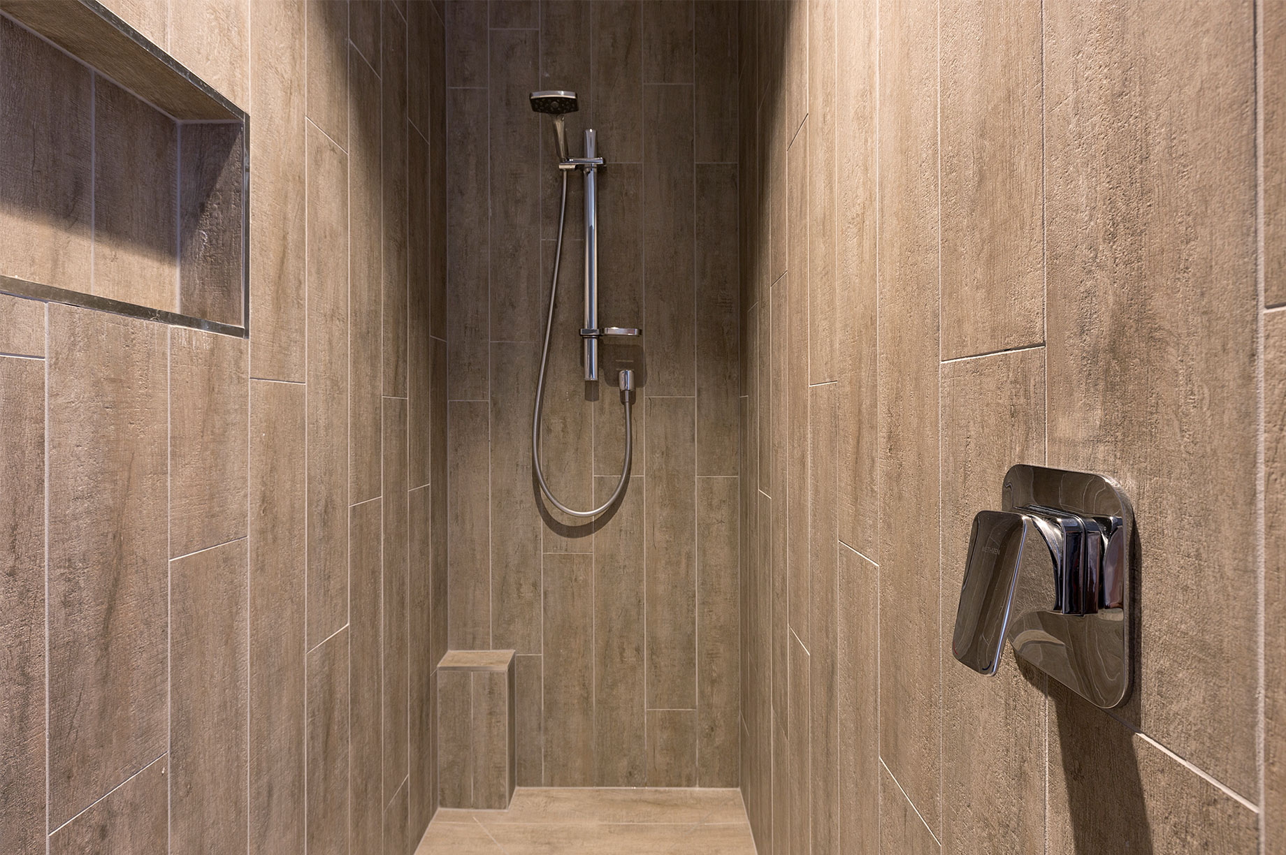 Large shower with brown tiles