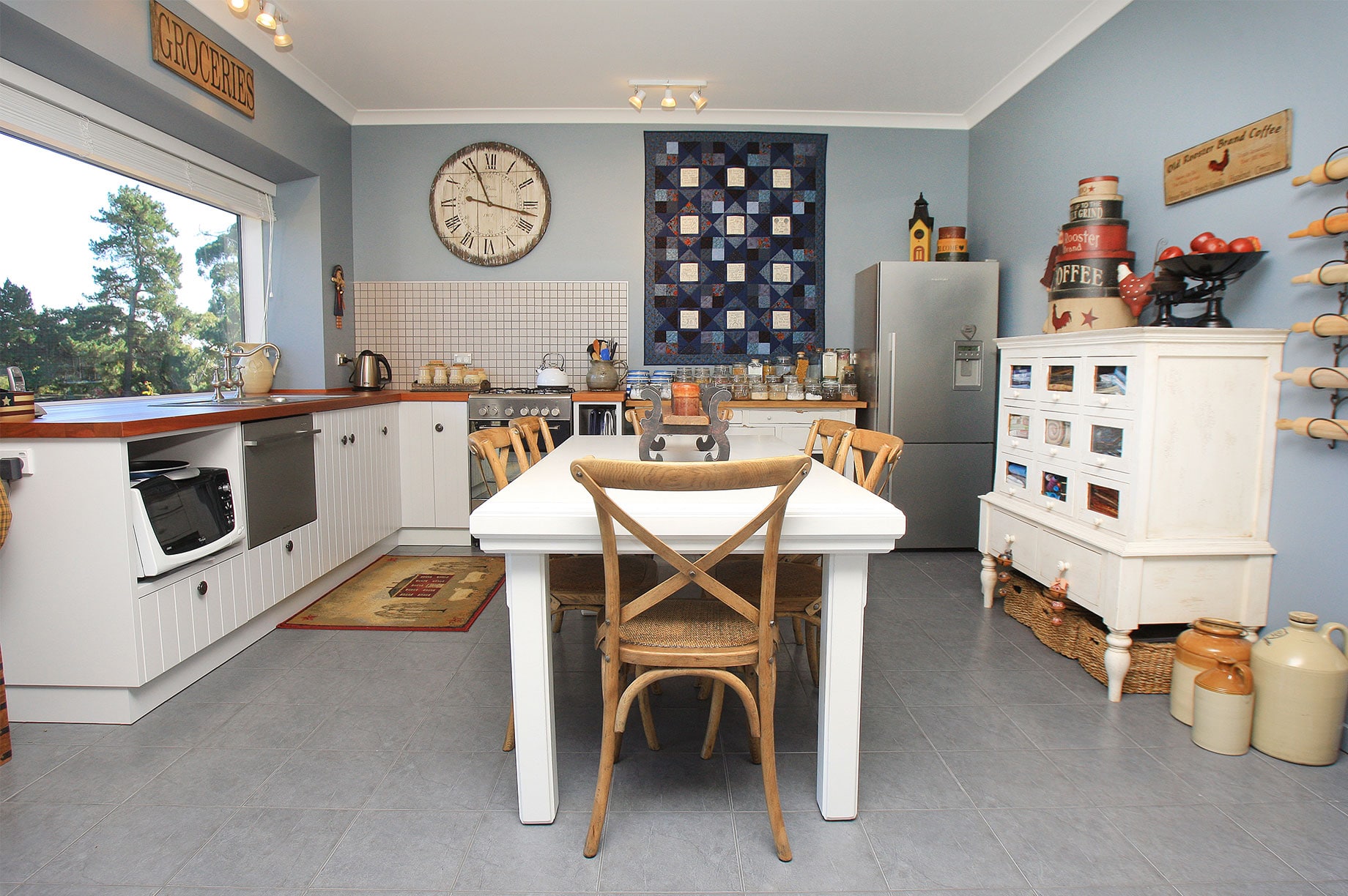 Kitchen with white furniture and blue walls